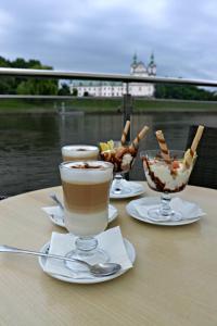 una mesa con dos vasos de café y un tazón de comida en The Boat - Hostel&Chill, en Cracovia 12 fotos más