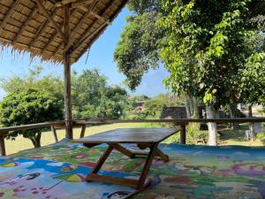 a picnic table under a straw roof on a rug at Chiang Dao Hostel in Chiang Dao