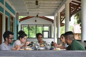 un gruppo di persone sedute a tavola che mangiano cibo di Funky Leopard Safari Lodge Bordering Yala National Park a Kataragama