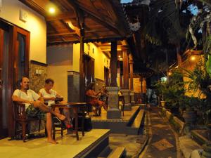 a group of people sitting at a table in a building at Dewi Antara Homestay in Ubud