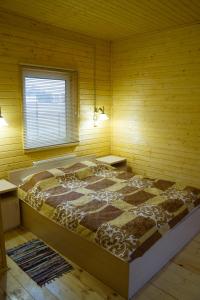 1 dormitorio con 1 cama grande en una pared de madera en Vladimirskiy Hutorok en Vladimir