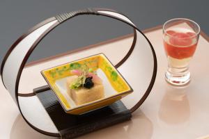 un piatto di cibo su un tavolo accanto a una bevanda di Isoaruki no Yuyado Ushiogumo -6 years or older- a Kawazu