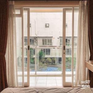 a bedroom with a large window with a view of a building at Gateway Pasteur Apartment by Secret Rooms in Bandung