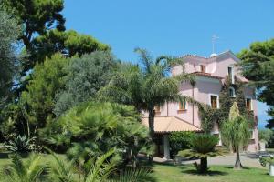 a pink house with trees in front of it at Capo Santa Fortunata in Sorrento