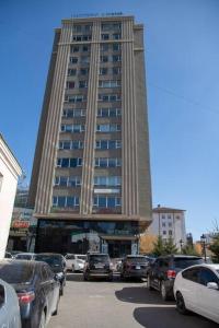 a large building with cars parked in front of it at Lovely 2 BR unit with city view in Ulaanbaatar