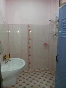 uma casa de banho com um lavatório e um WC. em ชมจันทร์รีสอร์ท ไชยา Chomjan resort 
