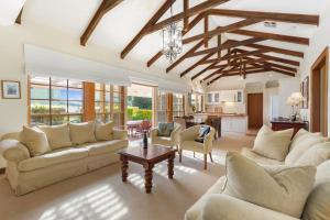 Una gran sala de estar con sofás y una mesa. en Elcott House - Carrickalinga - C21 SouthCoast Holidays, en Carrickalinga 14 fotos más