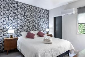 a bedroom with a bed with a floral accent wall at VIOLETA HOTEL Boutique in Artigas