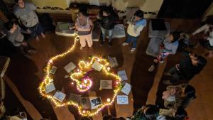 een groep mensen die rond een tafel met lichten staan bij Hostal Tribu Malinalco in Malinalco