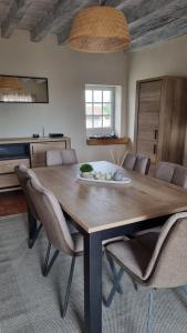 a dining room with a wooden table and chairs at Maison de charme au cœur des vignes du Beaujolais in Saint-Georges-de-Reneins