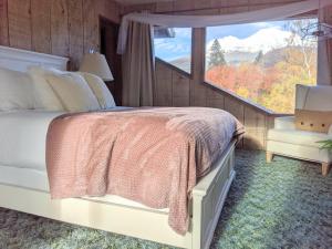 a bedroom with a bed and a large window at 4 Elements House:Central, Views-Every Rm, AC, Pets in Mount Shasta