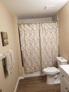 a bathroom with a toilet and a shower curtain at Home Sweet Home in Fort Myers