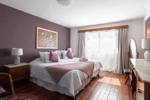 a bedroom with a bed with pink pillows and a window at VIOLETA HOTEL Boutique in Artigas
