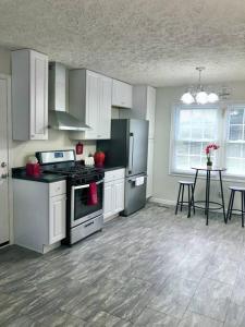 una cocina con electrodomésticos blancos y una mesa con sillas. en Trestle Creek Farm- farmhouse suite, en Bloomington