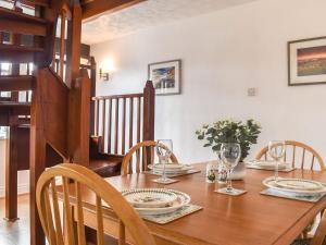 una mesa de comedor con platos y vasos. en The Coach House - Uk41070 en Wootton Bridge