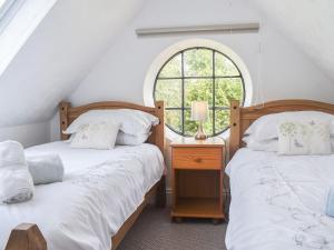 2 camas en una habitación con ventana en The Coach House - Uk41070 en Wootton Bridge