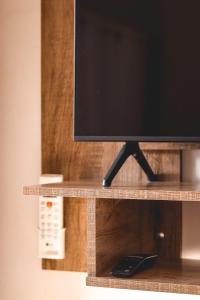 a flat screen tv sitting on a wooden shelf at Pousada Chalés do Vale - Vale dos Vinhedos in Bento Gonçalves