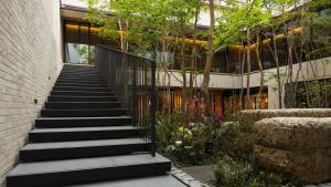 a staircase leading up to a building with trees and flowers at Hotel Metropolitan Kamakura in Kamakura
