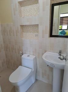 a bathroom with a white toilet and a sink at Happy's Homestay in Boracay