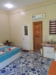 sypialnia z łóżkiem oraz łazienka z umywalką w obiekcie Happy's Homestay w mieście Boracay