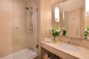 a bathroom with a tub and a sink and a shower at Sofitel Sydney Wentworth in Sydney