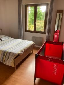 - une chambre avec un lit et une commode rouge dans l'établissement Maison de campagne de plein pied., à Plougonven