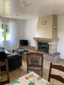 sala de estar con chimenea y sofá en Maison de campagne de plein pied., en Plougonven