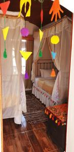 a bedroom with a canopy bed with colorful paper kites at Old Nubian guest house in Aswan