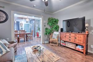 a living room with a large television and a table at Historic Galveston Home Walkable Neighborhood! in Galveston