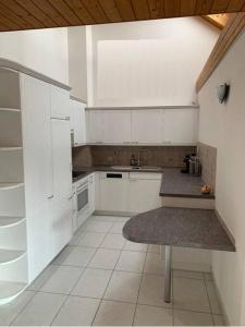 una pequeña cocina con armarios blancos y fregadero en Sunny private Apartment in an amazing valley en Wila