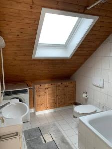 a bathroom with a skylight and a toilet and sink at Sunny private Apartment in an amazing valley in Wila
