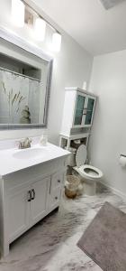 ein Badezimmer mit einem Waschbecken, einem WC und einem Spiegel in der Unterkunft Cochrane Diggs in Cochrane