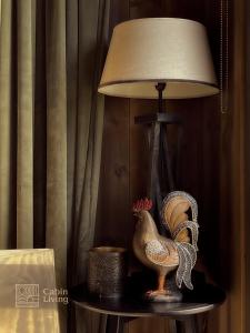 une lampe avec un poulet sur une table à côté d'une lampe dans l'établissement Modern unique cabin fantastic location Skeikampen, à Svingvoll