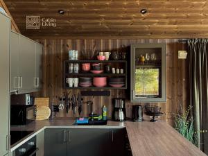 a kitchen with wooden walls and a counter top at Modern unique cabin fantastic location Skeikampen in Svingvoll