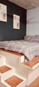 1 cama blanca en un dormitorio con 2 cuadros en la pared en Affordable Staycation Home for 2-3 People! en Dauin