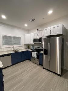 a kitchen with blue cabinets and a stainless steel refrigerator at City Serenity-2BR Home away from Home. 6 Min from ATL Airport in Atlanta