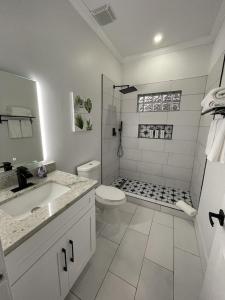 a white bathroom with a toilet and a sink at City Serenity-2BR Home away from Home. 6 Min from ATL Airport in Atlanta