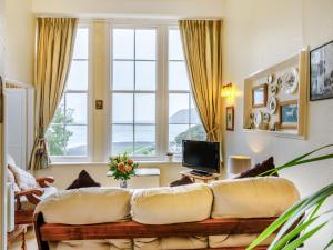 Una sala de estar con un sofá y una ventana grande. en Clooneavin Apartment 2, en Lynmouth