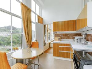 cocina con armarios de madera, mesa y ventana en Clooneavin Apartment 2, en Lynmouth