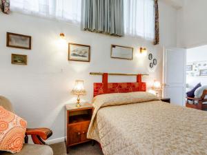 een slaapkamer met een bed en een stoel bij Clooneavin Apartment 2 in Lynmouth