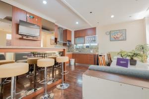 uma cozinha e sala de estar com um bar com bancos em Singgahsini Casa D Elok Near PIM 1 em Jakarta