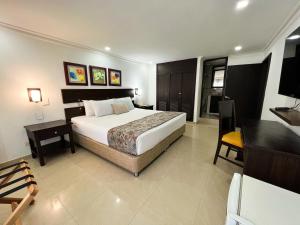 a bedroom with a large bed and a desk and a bed sidx sidx sidx sidx at Hotel Arhuaco Rodadero in Santa Marta