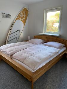 ein Schlafzimmer mit einem Bett mit Surfbrett darauf in der Unterkunft Freistehendes Einfamilienhaus mit Boddenblick Nähe Ostsee in Fuhlendorf