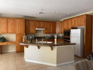 cocina con armarios de madera y nevera blanca en LAKE view Elk Grove house 3300 sqf 5 bedrooms, en Elk Grove