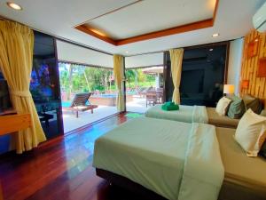 a bedroom with two beds and a balcony with a pool at Koh Kood Beach Resort in Ko Kood +85 photos