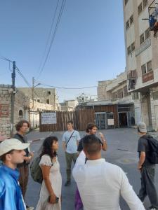a group of people walking down a street at Friends Hostel.Area B in Hebron