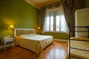 una camera da letto verde con un letto e una finestra di Hotel Gennarino a Livorno