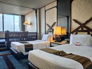 チェンマイにあるChiang Mai Orchid Hotel SHA EXTRA PLUSのベッド2台と窓が備わるホテルルームです。