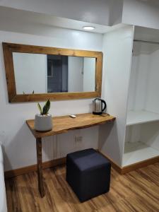 a room with a table with a mirror and a stool at Borj Place in Naga