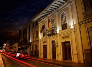 un edificio con banderas al lado de una calle por la noche en Santa Lucia House - Forum, en Cuenca